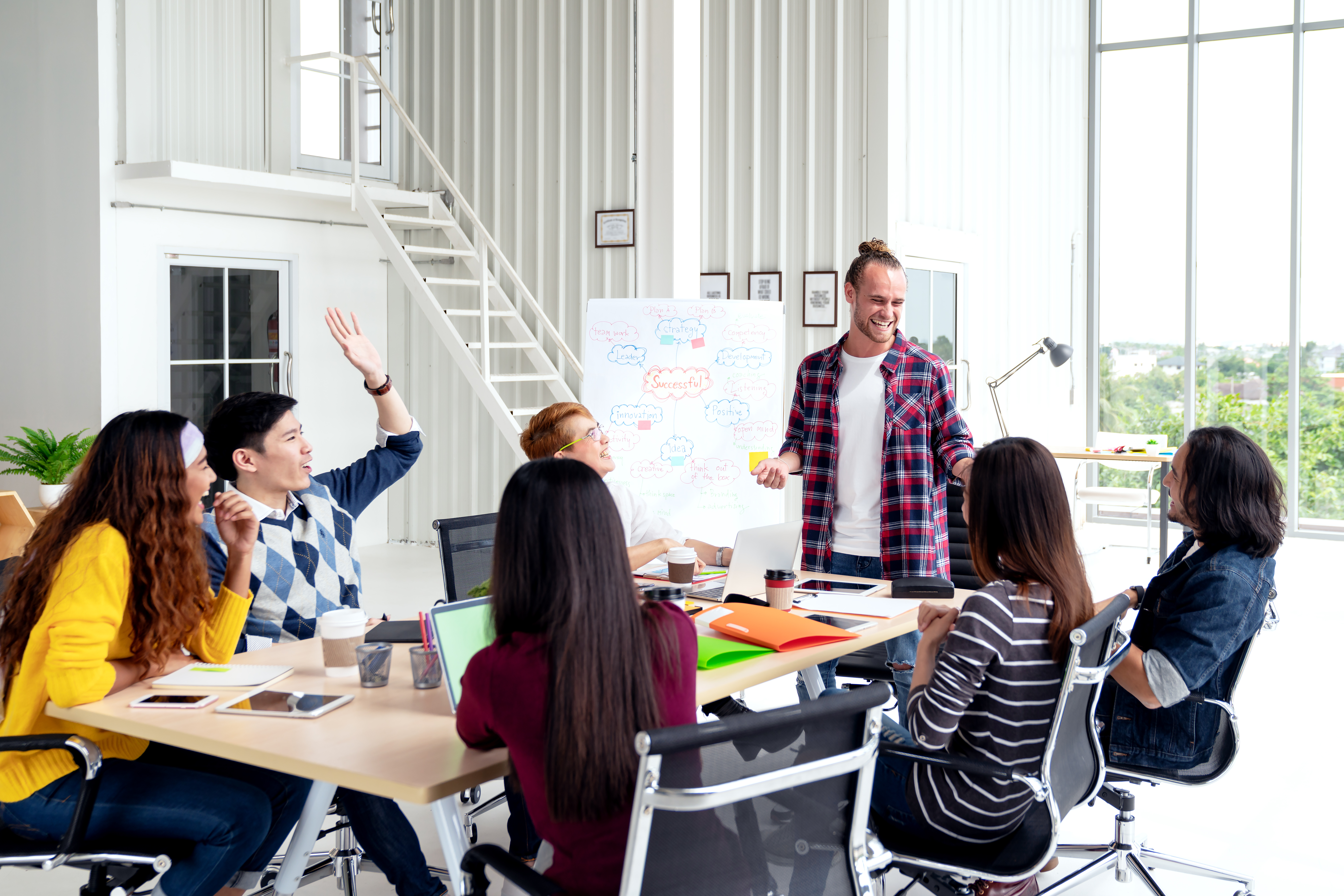 Group of young attractive asian creative design team meeting,smiling and laughing at office workshop. Asian employee engaged together with effective and productive meeting and happy workplace concept.