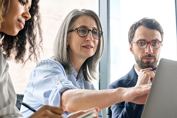 Older worker with younger colleagues in a multigenerational workforce.